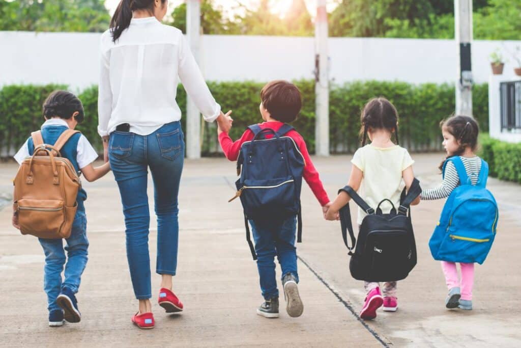 Children with backpacks heading to school after parents used back to school house cleaning tips
